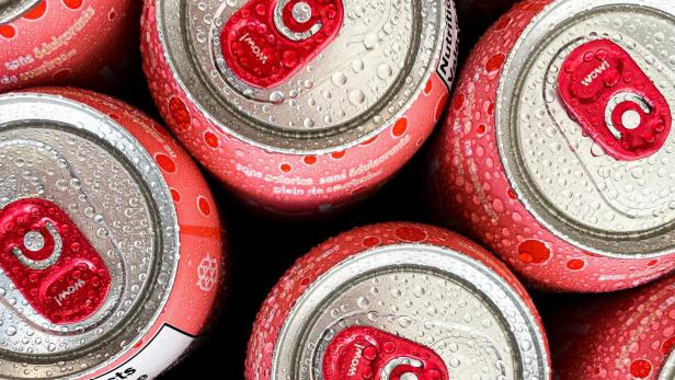 Rote Getränkedosen, deren Außenseite von feinen Kondenstropfen bedeckt ist