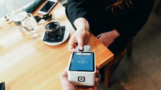 Gen Z: Geben junge Leute kein Trinkgeld mehr? Hier gibt es Antworten. Eine Frau, die per Karte im Restaurant zahlt.