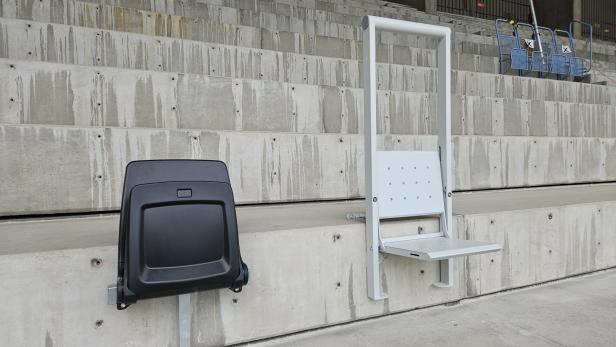So wird die Bestuhlung auf dem Sport-Club-Platz aussehen (links Sitzplätze, rechts Friedhofstribüne). Zwei unterschiedliche Sessel auf der Baustelle des Sport-Club-Platzes.