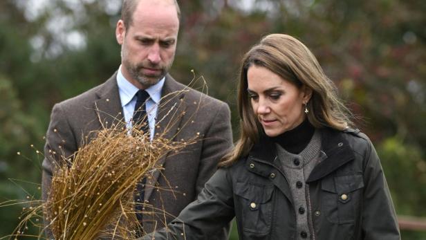 Prinz William und Kate inspizieren Garben auf einem Feld.