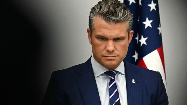 BELGIUM-NATO-DIPLOMACY-DEFENCE-SUMMIT Pete Hegseth blickt nach unten, im Hintergrund ist eine US-Flagge zu sehen.