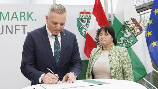 Mario Kunasek und Manuela Khom stehen an Tisch