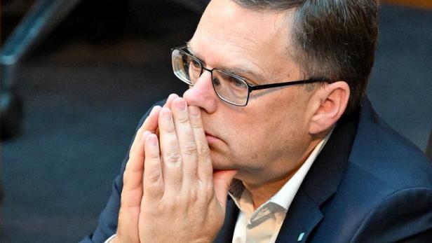 August Wöginger sitzt nachdenklich mit gefalteten Händen vor dem Gesicht im Nationalrat