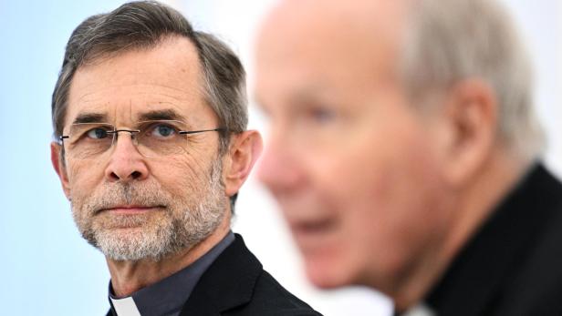 Josef Grünwidl blickt ernst, im Vordergrund ist Christoph Schönbornunscharf zu sehen.