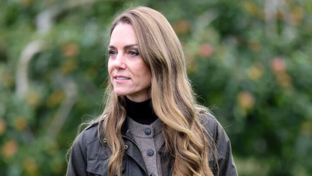Prinzessin Kate Prinzessin Kate mit langen, gewellten Haaren trägt eine Jacke und einen Rock im Freien.