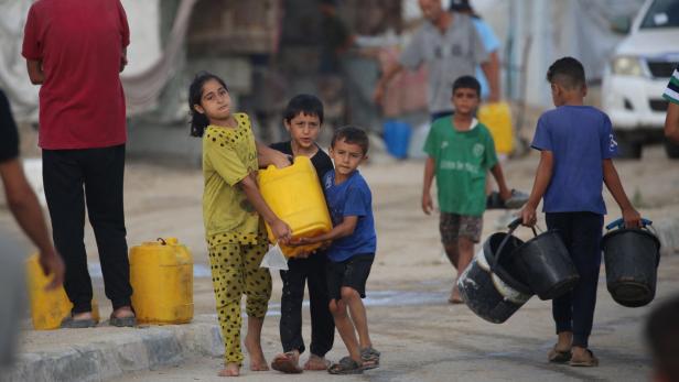 TOPSHOT-PALESTINIAN-ISRAEL-CONFLICT Kinder schleppen einen Wasserkanister