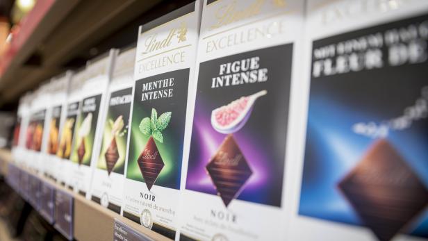Reihe von Lindt Excellence Schokoladentafeln im Regal, darunter Sorten wie Menthe Intense und Figue Intense.