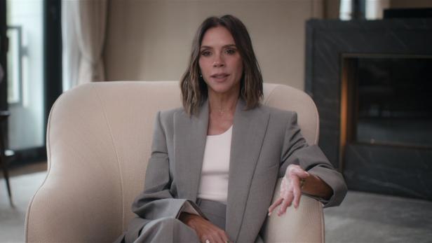 In der Netflix-Serie zeigt sich Victoria Beckham im grauen Blazer und weißem Shirt. 