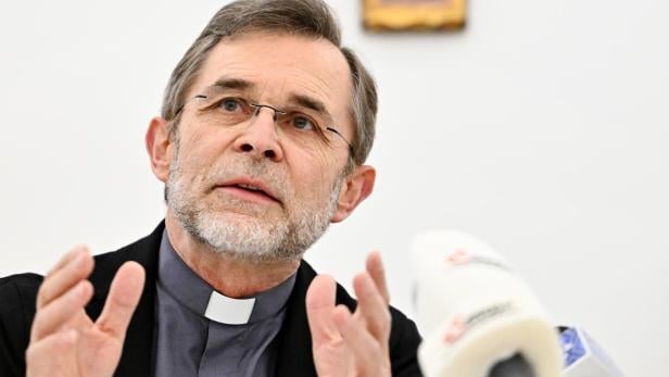 Priester vor Jesuskreuz