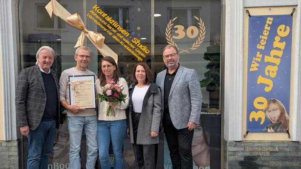 Mehrere Personen stehen vor Eingangstür eines Geschäfts
