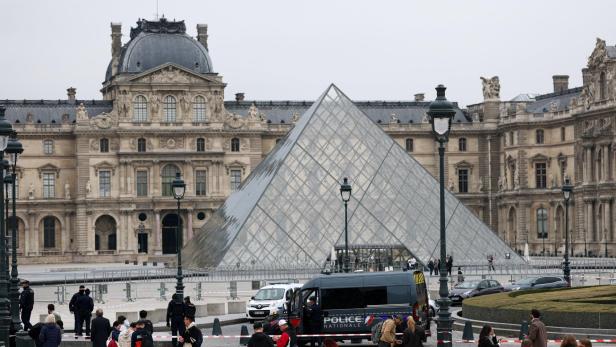 Police stand near the pyramid of the Louvre museum after reports of a robbery, in Paris Aufregung vor dem Louvre.