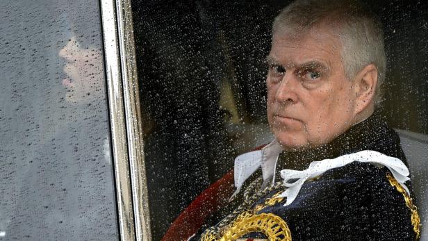 Prinz Andrew Prinz Andrew blickt ernst aus einem verregneten Autofenster, gekleidet in eine reich verzierte Uniform.