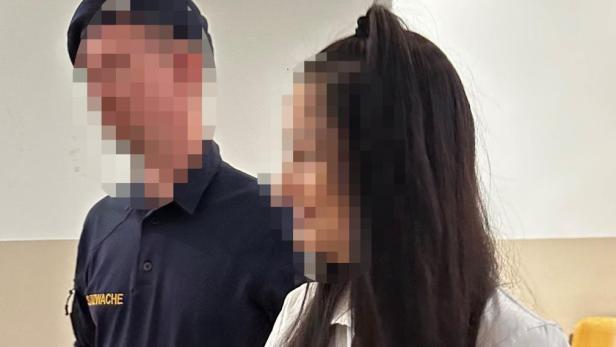 Eine Frau in Handschellen und ein Justizwachebeamter