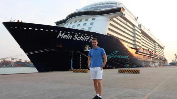 46-219506093 Ein Mann steht vor dem Kreuzfahrtschiff "Mein Schiff 3" im Hafen.