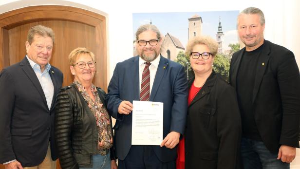 Ein Gruppenbild von mehreren Personen der SPÖ, darunter Bürgermeister Molnar am rechten Rand. In der Mitte steht Klaus Bergmaier im Anzug und hält eine Urkunde.