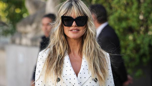 Heidi Klum Heidi Klum in einem weißen Kleid trägt eine dunkle Sonnenbrille.