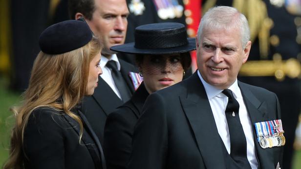 Prinz Andrew mit seinen Töchtern Mehrere Personen in dunkler Kleidung, darunter Prinz Andrew mit Orden, sind zu sehen.