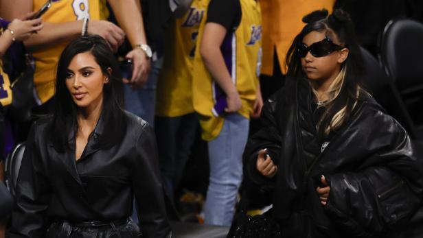 Kim Kardashian und North West Kim Kardashian und ihre Tochter, beide in Schwarz gekleidet, sitzen bei einem Lakers-Spiel.