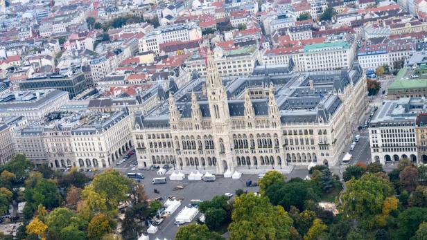 Luftaufnahme des Wiener Rathauses mit Zelten auf dem Rathausplatz und umliegender Bebauung.