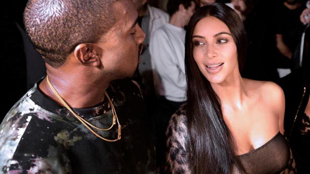 Kanye West und Kim Kardashian Kanye West und Kim Kardashian stehen inmitten einer Menschenmenge.