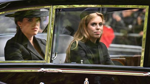 Prinzessin Beatrice und Prinzessin Eugenie sitzen in einem schwarzen Auto.