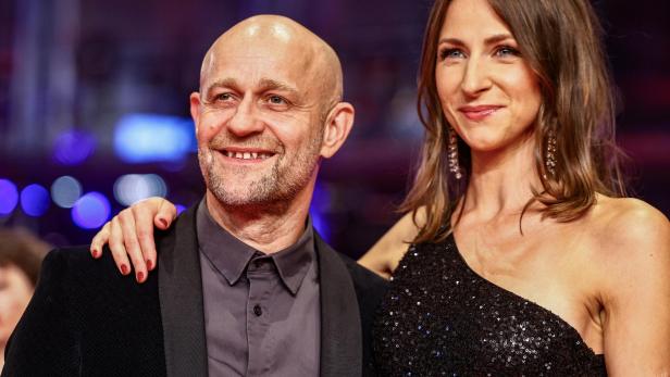 Jürgen Vogel Jürgen Vogel bei einer Veranstaltung in einem schwarzen Anzug und eine Frau im Paillettenkleid.