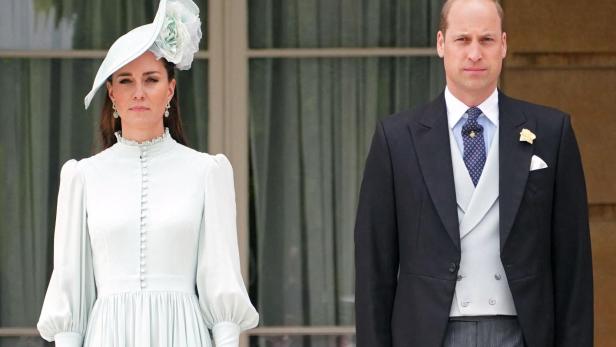 Prinzessin Kate und Prinz William Kate und William stehen formell gekleidet vor einem Gebäude.