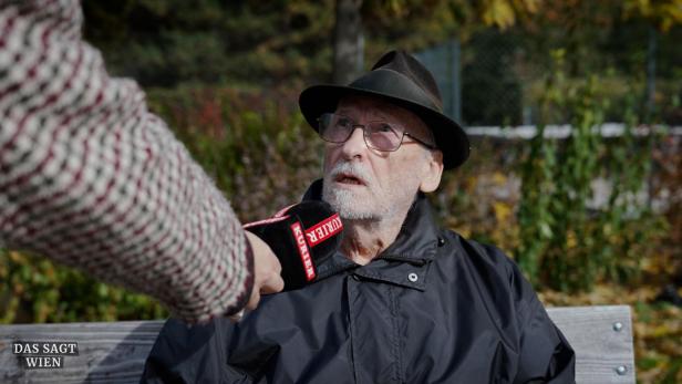 Mann mit Hut mit KURIER Mikrofon