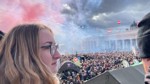 Eine junge Frau beobachtet die Parade auf dem Heldenplatz.