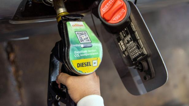 Diesel Eine Hand betankt ein Auto mit Diesel "Excellium", wobei der Tankdeckel geöffnet ist.