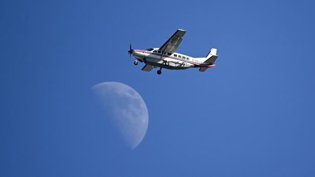 Golf The Open 2021 -  Third Round Ein kleines Flugzeug fliegt vor einem hellblauen Himmel mit einem Mond im Hintergrund.