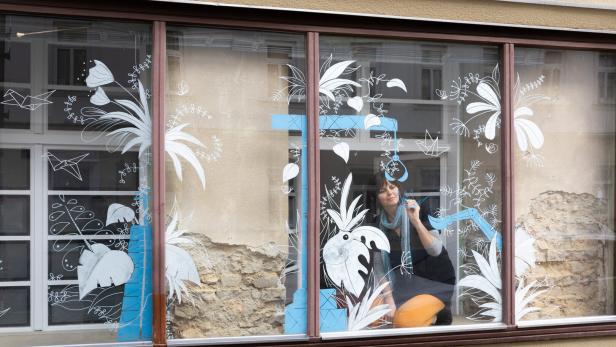 Schaufenster eines Grafikbüros in Wien Hernals. Die Illustratorin Nadine Kappacher zeichent mit Kreidestiften auf das Glas