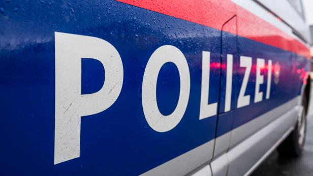 Schriftzug der Polizei an der seitlichen Tür eines Einsatzwagens.
