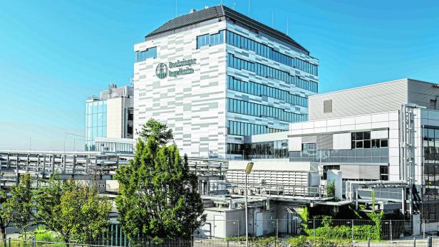 Das Gebäude von Boehringer Ingelheim mit moderner Fassade unter blauem Himmel.