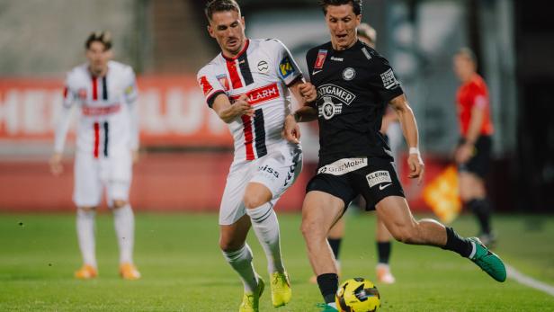 SOCCER - OEFB Cup, Admira vs Sturm Zwei Fußballspieler kämpfen um den Ball auf dem grünen Rasen.