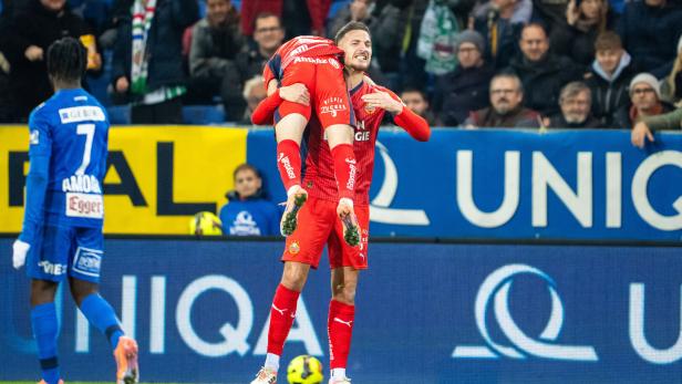 FUSSBALL: ÖFB-CUP - ACHTELFINALE: SKN ST. PÖLTEN - SK RAPID Zwei Rapidler feiern ein Tor, einer hebt den anderen hoch, während Zuschauer jubeln.