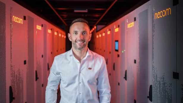 Gründer Walter Kreisel vor einem großen Batteriespeicher von Neoom.