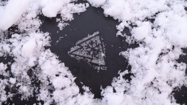 Schneeflockensymbol auf Autoreifen, mit Schnee runderhum