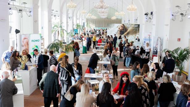 Eine große Gruppe von Menschen in einem weitläufigen Saal.