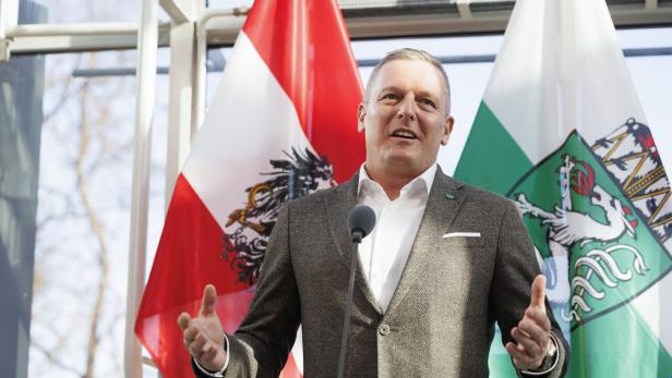 Landeshauptmann Kunasek vor Östereich- und Steiermark-Flaggen