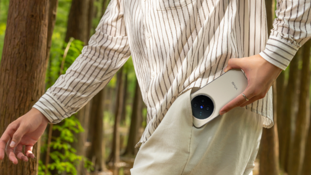 Ein Mann geht und steckt sein Handy in die Hosentasche.