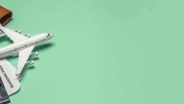 Gegenstände für Reisen und Flüge: Tickets, Reisepass, Geld, Sonnenbrille auf farbigem Hintergrund.