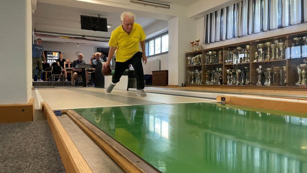 Bruno Wohlmuth im gelben Trikot scheibt eine Kugel auf der Kegelbahn.