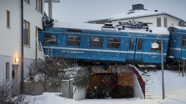 epa03536502 Swedish police at the scene after a local train embedded itself in a residential house after being derailed in Saltsjoebaden outside Stockholm, Sweden, 15 January 2013. Reports state that no resident in the building was injured in the accident. EPA/JONAS EKSTROEMER SWEDEN OUT