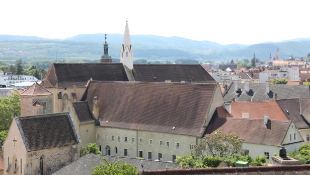 Eine Aufnahme von den Dächern der Kremser Innenstadt - im Zentrum steht die Dominikanerkirche mit einem aufragenden Turm.