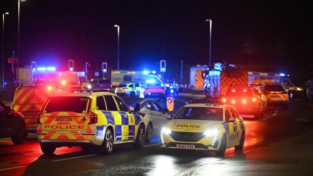Auf der Straße stehen mehrere Einsatzfahrzeuge von Polizei, Feuerwehr und Rettungsdienst mit eingeschaltetem Blaulicht.