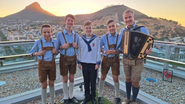 Vier Sängerknaben ´mit Chorleiter mit Blick auf die Berge rund um Kapstadt