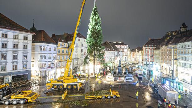 Christbaum wird von Kran auf Hauptplatz in Kran aufgestellt