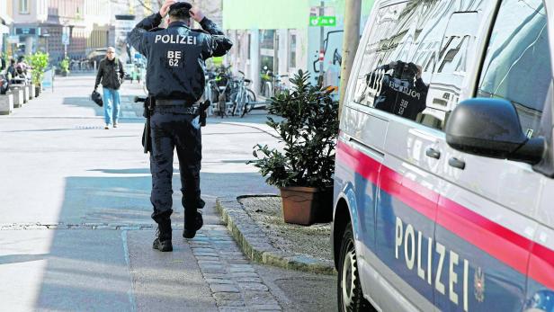 Polizist neben Polizeiauto