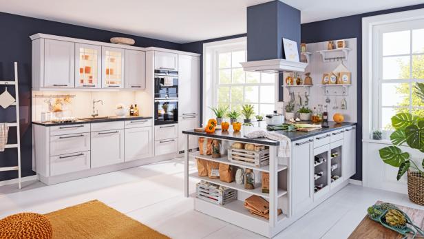 Moderne weiße Küche mit Kücheninsel, offenem Regal, Backofen, großen Fenstern und dunkelblauen Wänden.